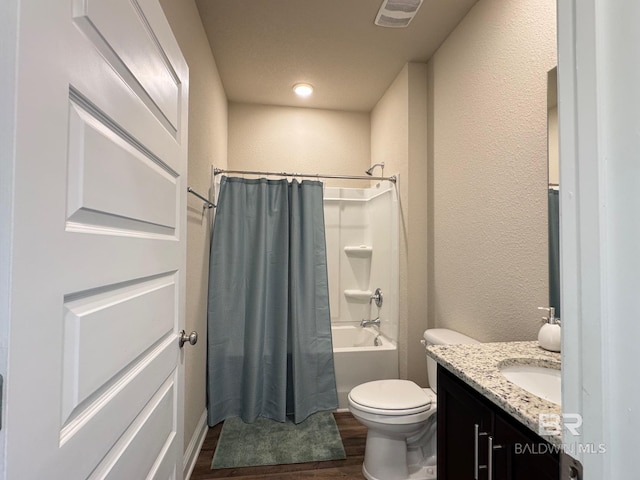 full bathroom with hardwood / wood-style floors, vanity, shower / bath combination with curtain, and toilet