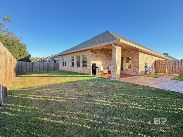 rear view of property featuring a yard and a patio