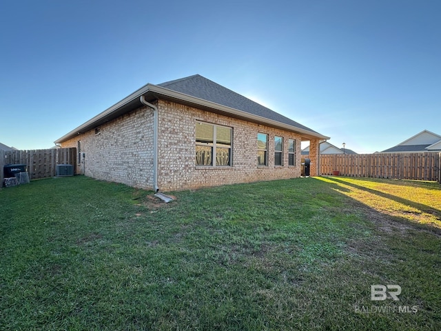 view of property exterior with a lawn and central air condition unit