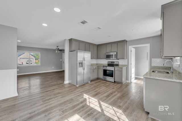 24477 Harvester Dr, Loxley, AL 36551 - kitchen featuring open floor plan, ceiling fan, gray cabinets, a sink, and appliances with stainless steel finishes