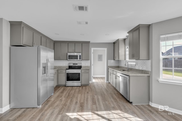 24477 Harvester Dr, Loxley, AL 36551 - kitchen with visible vents, gray cabinetry, a sink, light wood finished floors, and stainless steel appliances