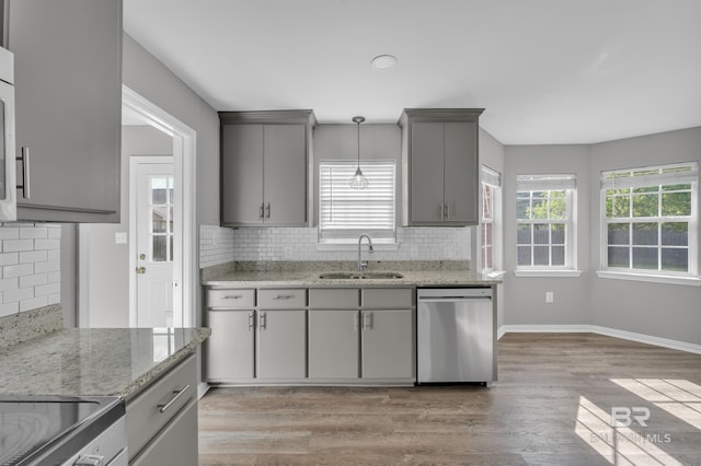 24477 Harvester Dr, Loxley, AL 36551 - kitchen with decorative backsplash, appliances with stainless steel finishes, a sink, gray cabinetry, and light wood-style flooring