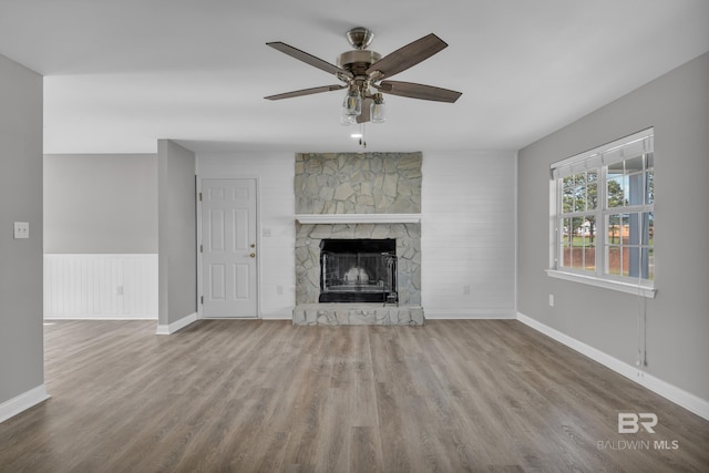 24477 Harvester Dr, Loxley, AL 36551 - unfurnished living room featuring ceiling fan, a stone fireplace, and wood finished floors