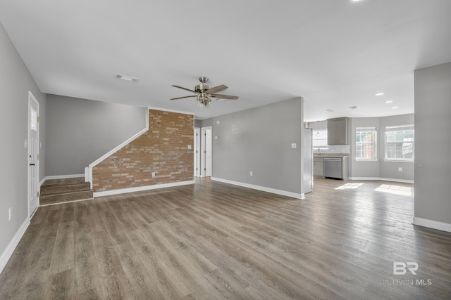 24477 Harvester Dr, Loxley, AL 36551 - unfurnished living room featuring baseboards, ceiling fan, wood finished floors, and visible vents