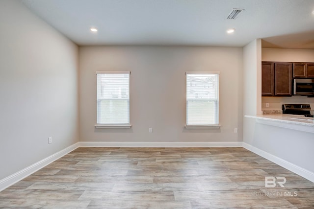 kitchen featuring stainless steel appliances, light hardwood / wood-style flooring, and a wealth of natural light