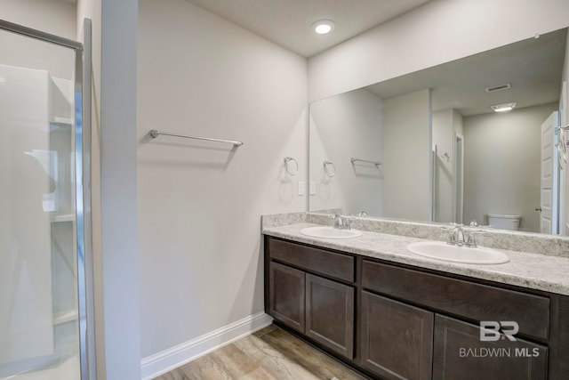 bathroom with wood-type flooring, vanity, and toilet