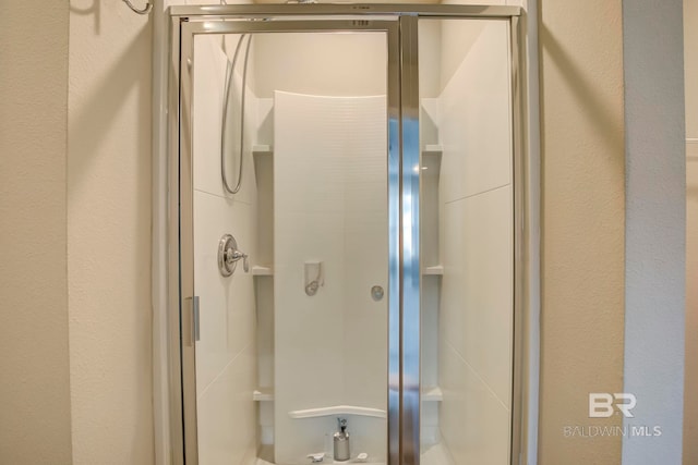 bathroom featuring a shower with shower door