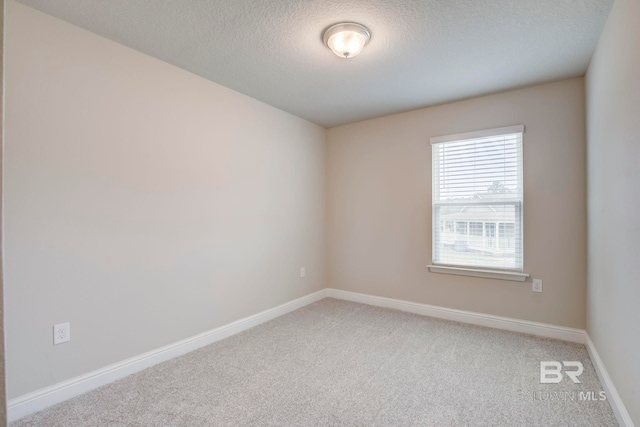 carpeted spare room with a textured ceiling