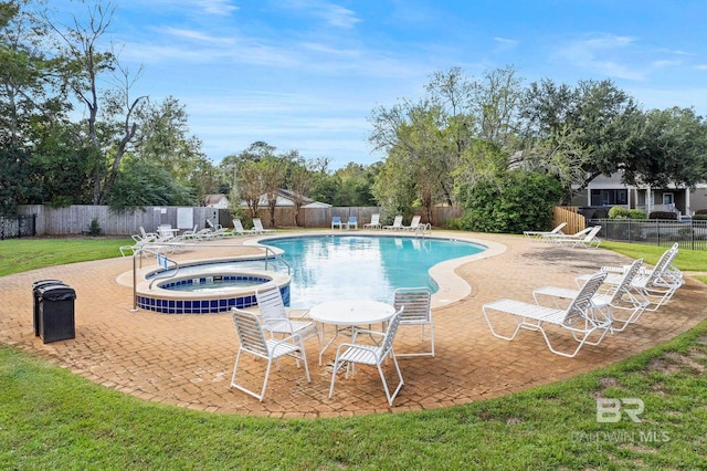 view of swimming pool featuring a lawn, a community hot tub, and a patio