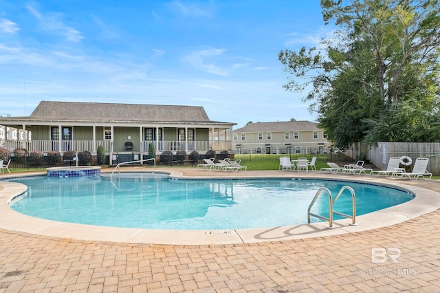 view of swimming pool with a patio area and a hot tub