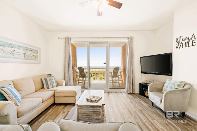 living area with ceiling fan, baseboards, and wood finished floors