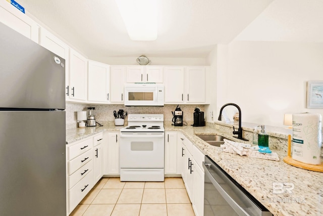 kitchen featuring white cabinets, light stone countertops, stainless steel appliances, a sink, and light tile patterned flooring