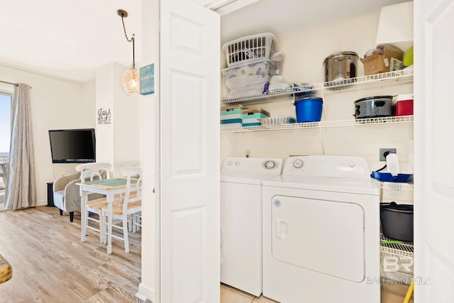 clothes washing area featuring laundry area, light wood finished floors, and independent washer and dryer