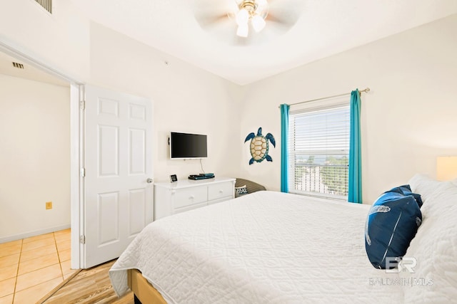 bedroom with light tile patterned flooring, ceiling fan, and baseboards