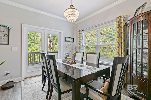 dining room featuring a notable chandelier, a healthy amount of sunlight, wood-type flooring, and french doors