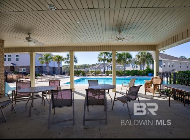 view of patio with ceiling fan and a community pool