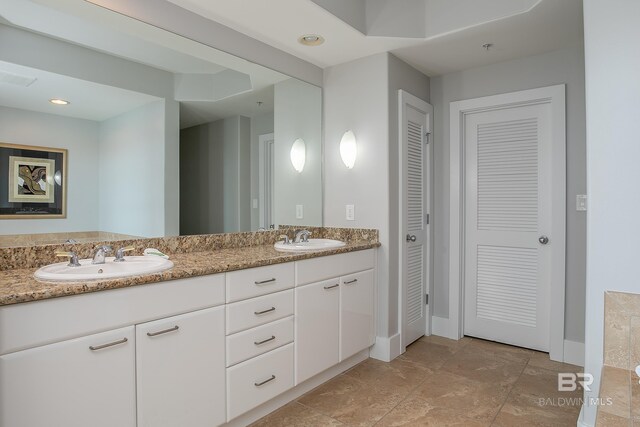 bathroom with dual bowl vanity and tile patterned floors