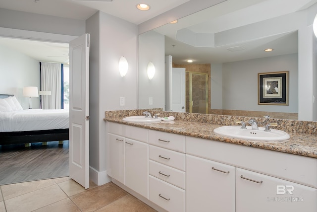 bathroom with tile patterned floors, double sink vanity, and walk in shower