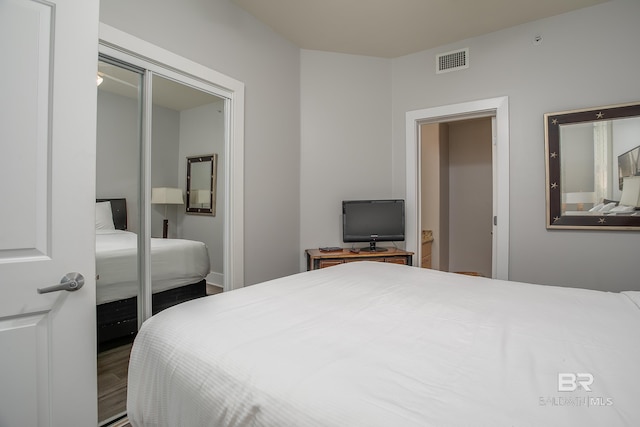 bedroom with hardwood / wood-style floors and a closet