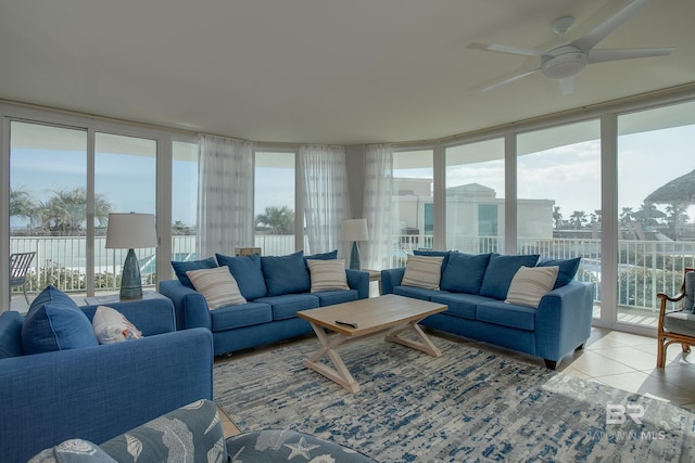 tiled living room with ceiling fan, plenty of natural light, and a wall of windows