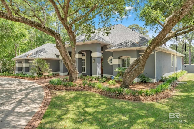 1352 W Fairway Dr, Gulf Shores, AL 36542 - view of front of property with a front yard, roof with shingles, and stucco siding