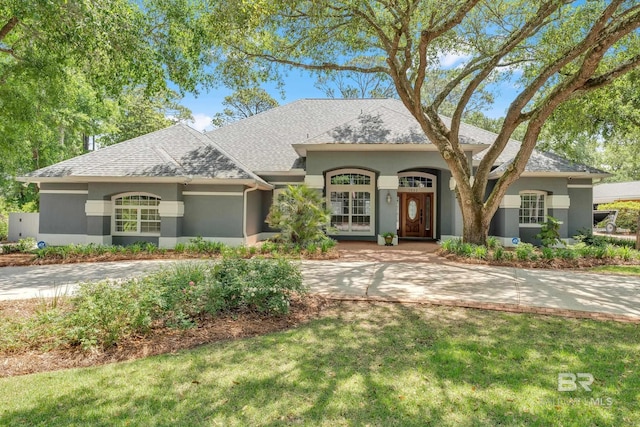 1352 W Fairway Dr, Gulf Shores, AL 36542 - view of front of property with a shingled roof, stucco siding, and a front yard