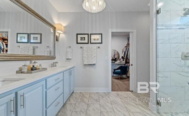 bathroom featuring a chandelier, marble finish floor, a spacious closet, a shower stall, and double vanity