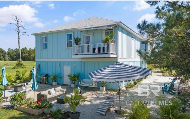 rear view of house with a patio, a balcony, and an outdoor living space