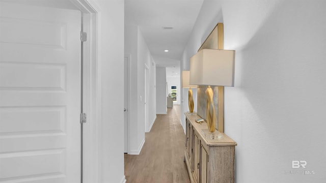 hallway with light wood-type flooring, baseboards, and recessed lighting