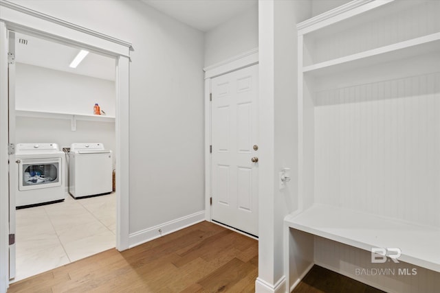 mudroom with baseboards, wood finished floors, and washer and clothes dryer