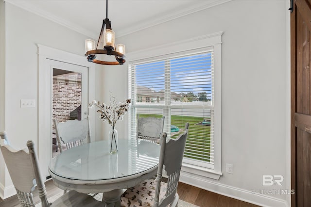 dining room with baseboards, a notable chandelier, wood finished floors, and crown molding