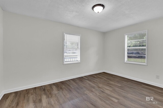 9241 Vallaris St, Mobile, AL 36608 - spare room with dark wood finished floors, baseboards, and a textured ceiling