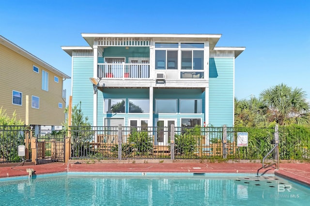 back of property featuring a community pool and a balcony