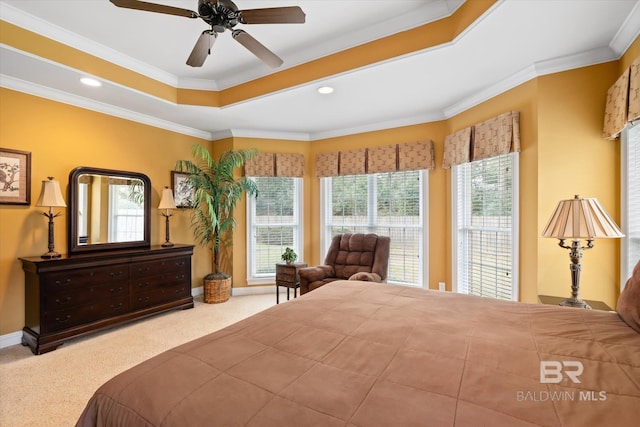 carpeted bedroom featuring a tray ceiling, recessed lighting, crown molding, baseboards, and ceiling fan