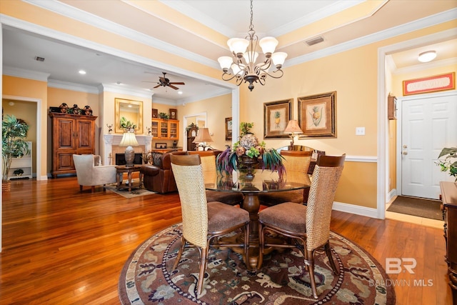 dining room with hardwood / wood-style floors, baseboards, visible vents, and ornamental molding