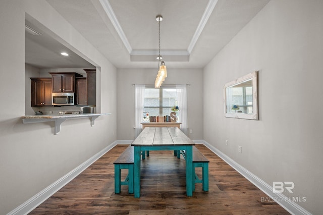 dining area featuring baseboards, ornamental molding, a raised ceiling, and dark wood-style floors