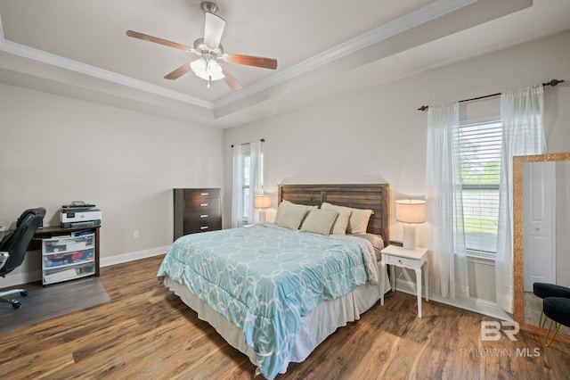 bedroom with crown molding, a raised ceiling, baseboards, and wood finished floors
