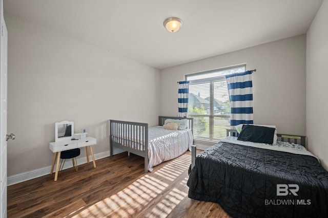 bedroom with baseboards and wood finished floors