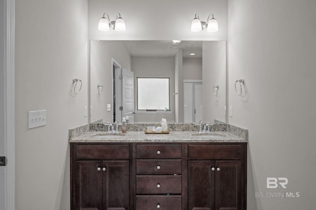 full bath with a sink, an enclosed shower, and double vanity