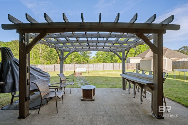 view of patio featuring a trampoline, an outdoor structure, a fenced backyard, a shed, and a pergola