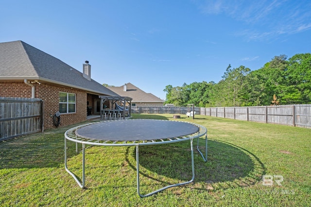 view of yard featuring a fenced backyard and a trampoline