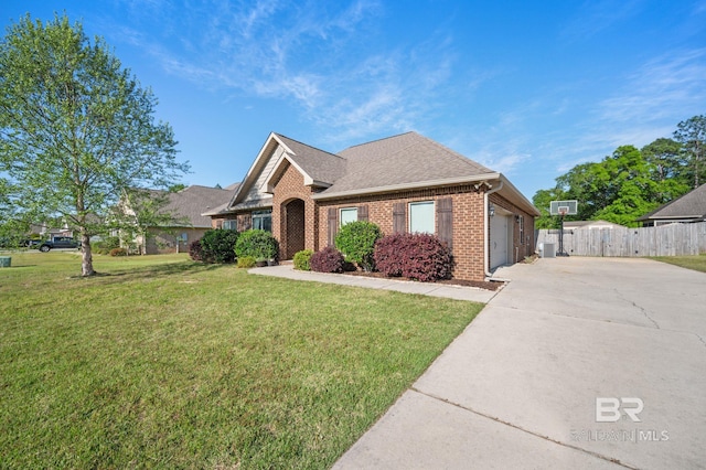 ranch-style house featuring fence, a front lawn, brick siding, a garage, and driveway