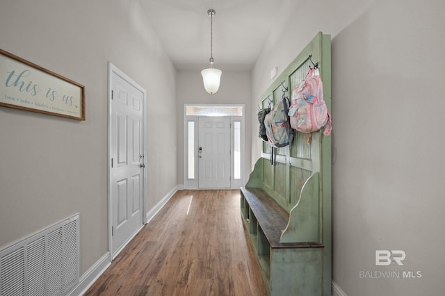 mudroom with baseboards, visible vents, and wood finished floors