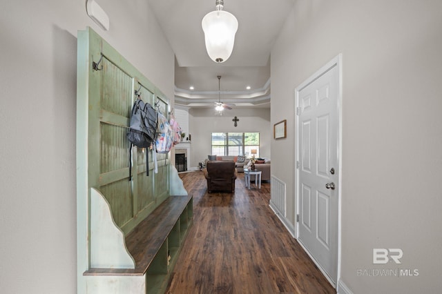 corridor with recessed lighting, baseboards, a raised ceiling, and dark wood-type flooring