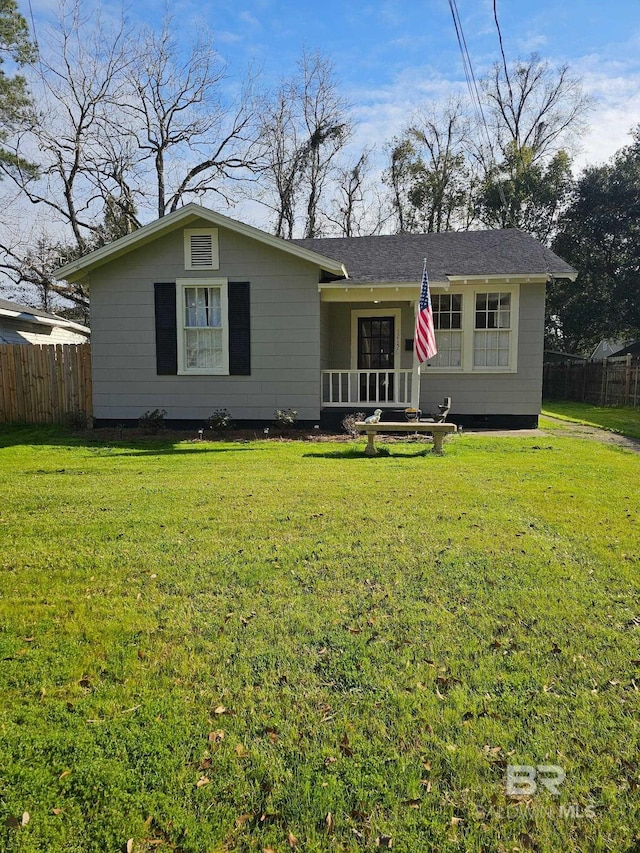 ranch-style home with a front yard and fence