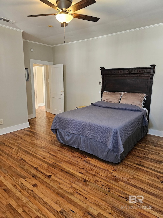 bedroom with baseboards, visible vents, ceiling fan, ornamental molding, and wood finished floors