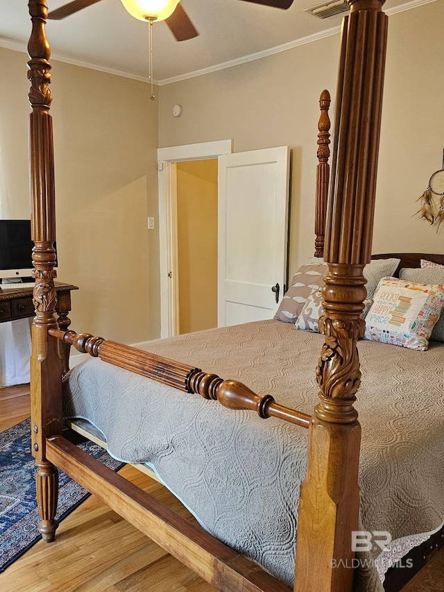 bedroom featuring ornamental molding, wood finished floors, and a ceiling fan