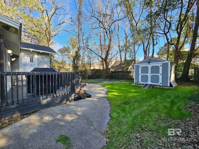 view of yard featuring an outbuilding, a fenced backyard, a wooden deck, and a shed