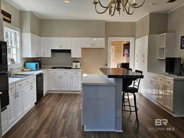 kitchen with dark wood-style floors, white cabinetry, a kitchen island, and black appliances