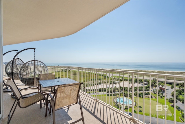 balcony with a water view and a view of the beach